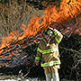 Fire fighter starts controlled burn of slash pile.