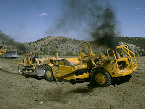 Earth mover and bulldozers clearing rangeland