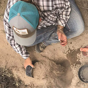 Jamie Ludwig Dafoe digging a hole on a range