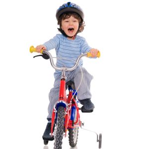 A boy riding a tricycle.