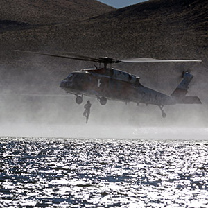 Navy Helicopter lowering man into lake