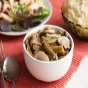 A bowl of green beans and mushrooms.