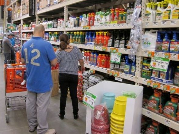 People shopping for pesticide products in a hardware store.