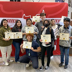 students showing off their certificates