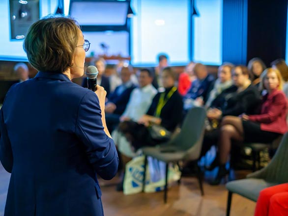 women speaking to crowd of people
