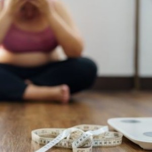 Woman sad about weight on scale.