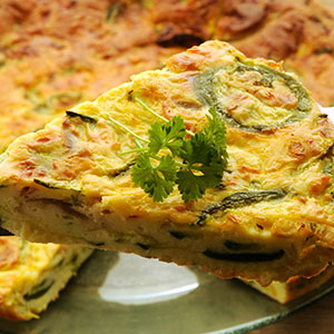 egg quiche with green vegetables and green leaf on top