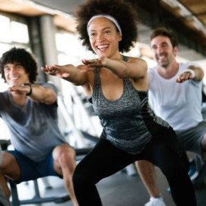 An exercise class squatting together.