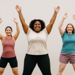 Three women with their hands up to the sky.
