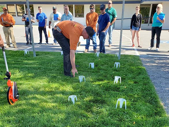 participant setting down catch cups on lawn