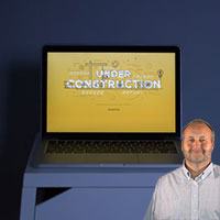 Computer with "Under Construction" on screen with Mike Bindrup