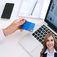 Person holding credit card while using a computer with Reyna Mendez