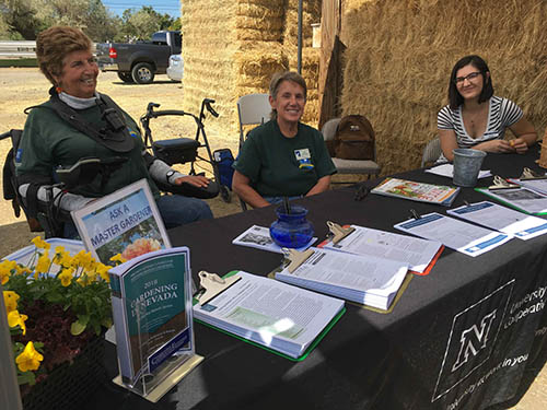 master gardeners sit at booth