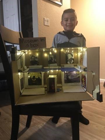 A young child with his family's museum in a box diorama