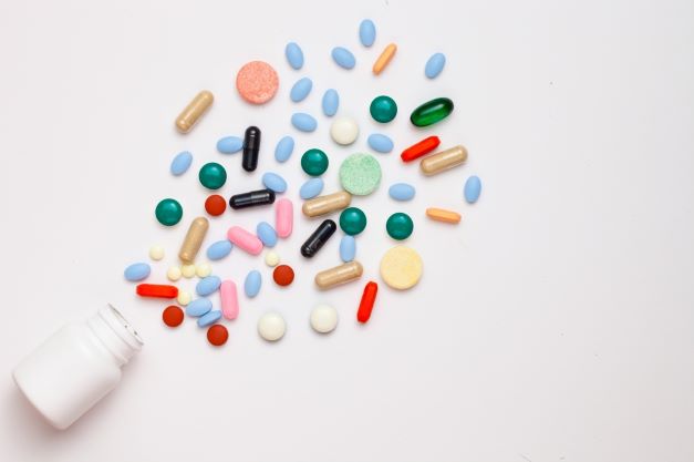 multicolored medications spilling form a prescription bottle