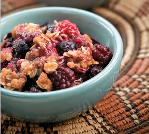 A bowl of mixed berries with a streusel topping.