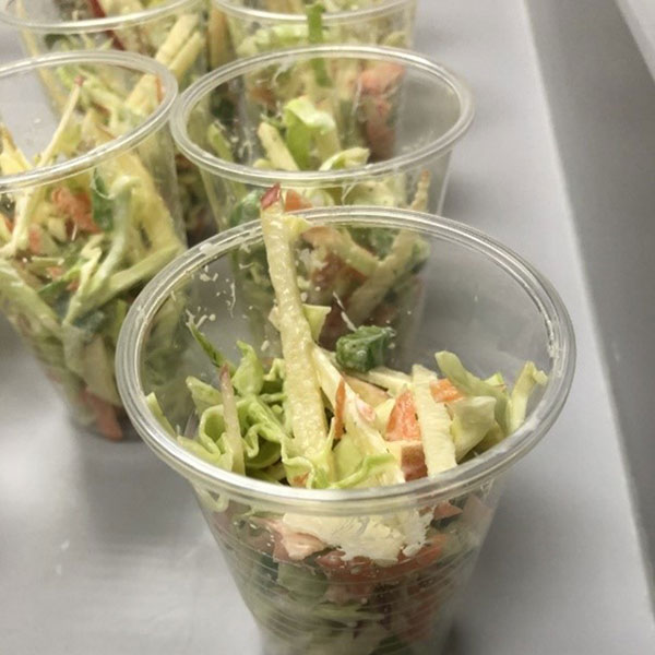 Cups of coleslaw on a white countertop.