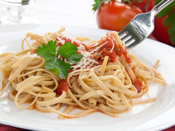 A plate of pasta with marinara and parmesan cheese. 