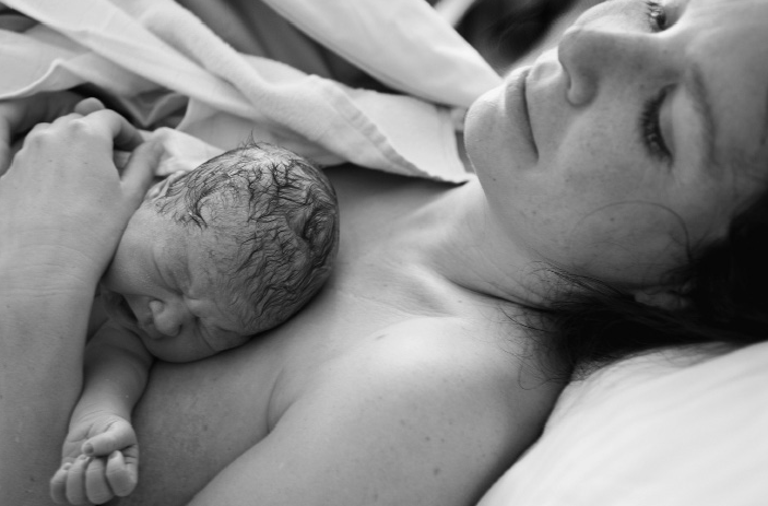 Mother holding newborn near chest