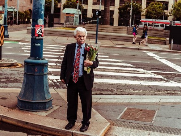 A man holding a bouquet of flowers.