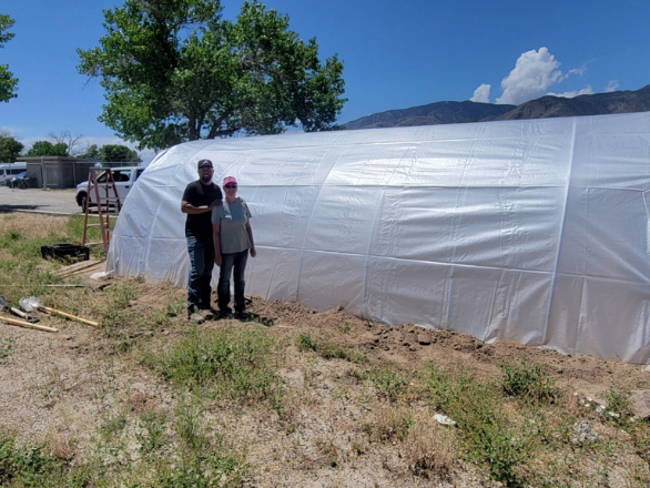 Hoop house with two people. 