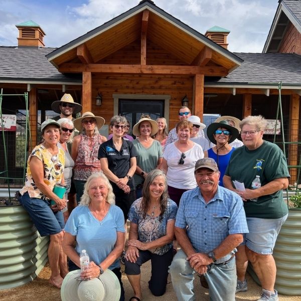 Master Gardeners and garden tour participants posing in front of gardens