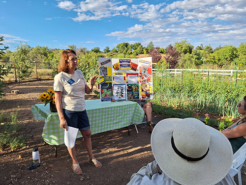 A person standing in front of a table outside at a park.