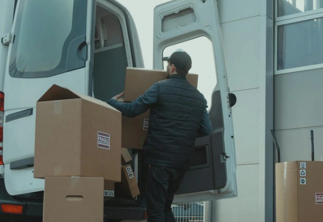  Un hombre carga cajas en una camioneta.