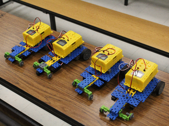 Four colorful robots are lined up next to each other on a table. 