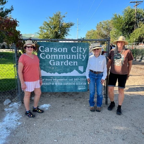 Master Gardeners posing in front of Carson City Community Garden sign