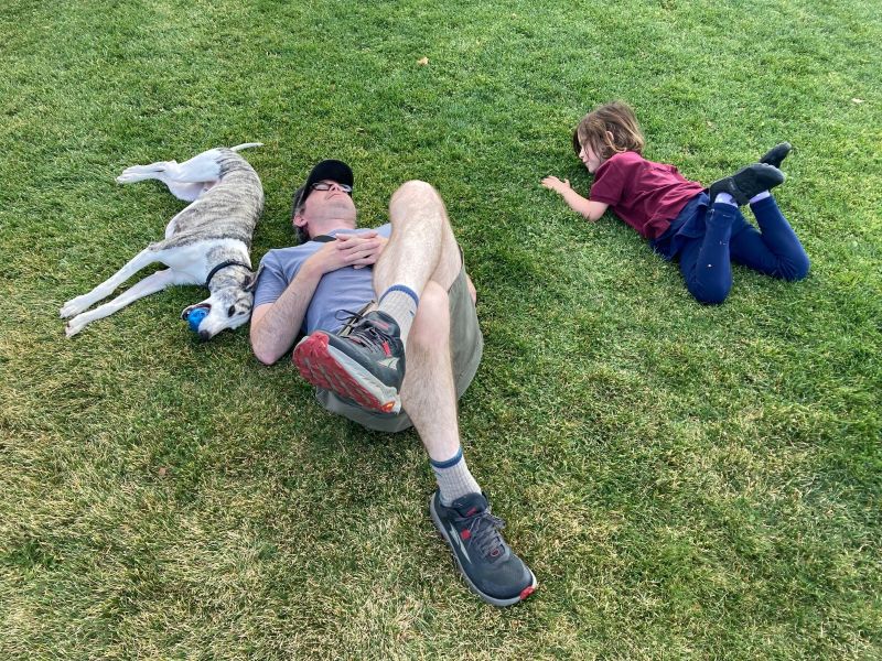 Family with dog playing on lawn.