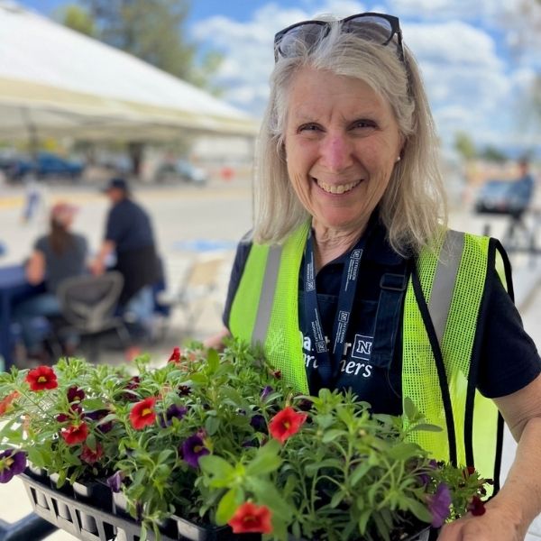 Master Gardener Cindy holding flowers at annual plant sale