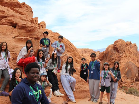 A group of kids standing in a red rock desert