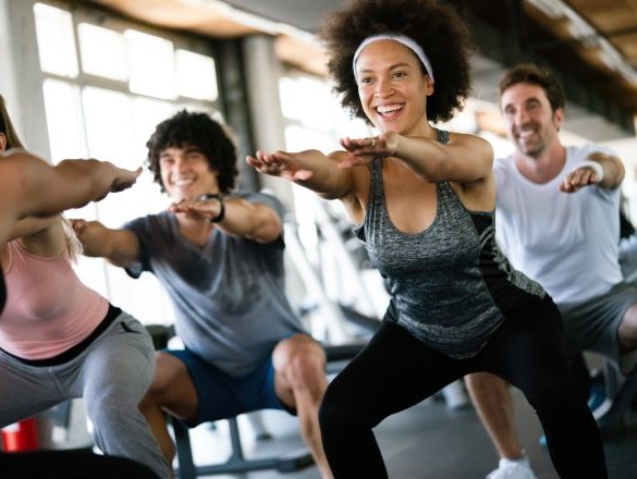 Group of people squatting in an exercise class.