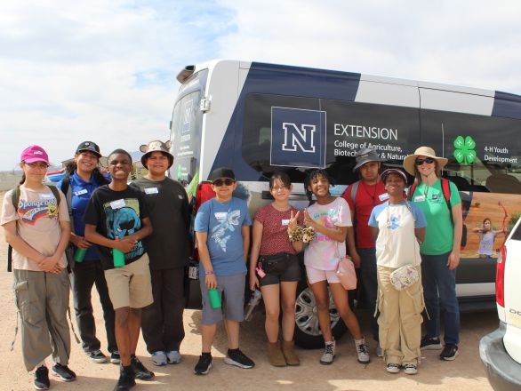 4-H staff and youth in front of a 4-H van