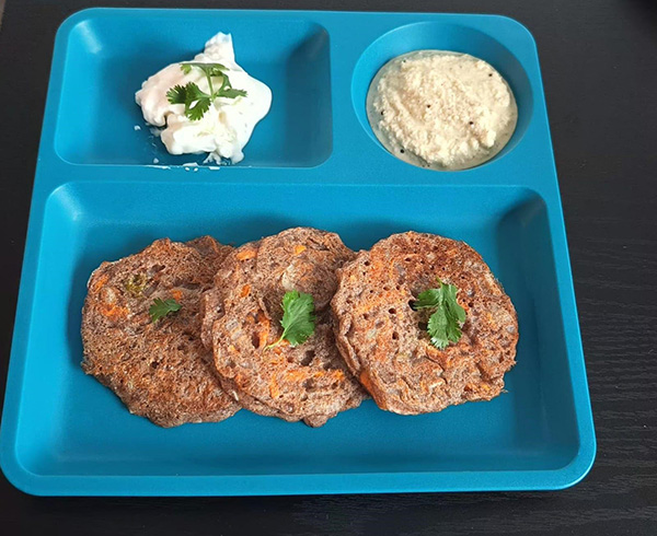 pancakes on a blue plate with two white colored mashed foods on each side.