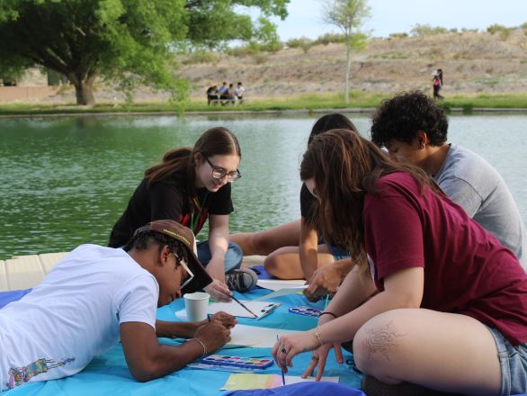 A group of teens waterpainting in a pond