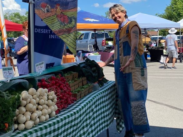 DFI staff at farmers market next to produce table