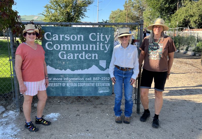 Master Gardener volunteers posing in front of the Carson City Community Garden sign