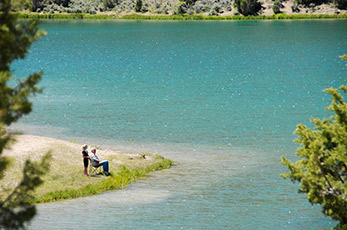 Peaceful Cave Lake with a couple of people fishing on the shore