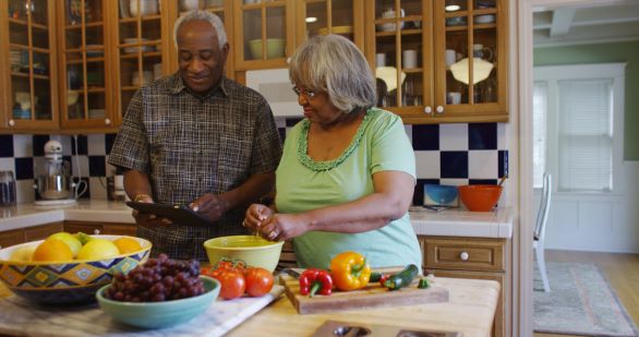 Older Black couple preparing a meal in their kitchen