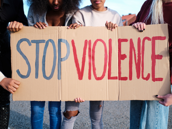 A group of young adults holding a sign that says "STOP VIOLENCE."