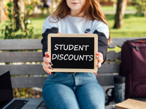 A student holding a "STUDENT DISCOUNTS" sign.